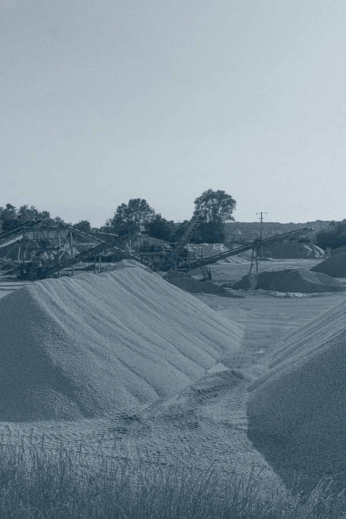Aggregate stockpiles and conveyor stackers at a production yard